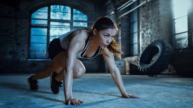 Athletic Beautiful Woman Does Running Plank as Part of Her Cross Fitness, Bodybuilding Gym Training Routine. Metafit